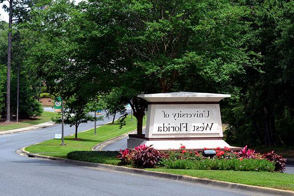 The main campus entrance features a 九州体育博彩bet9 sign surrounded by flowers in the median of University Parkway. 